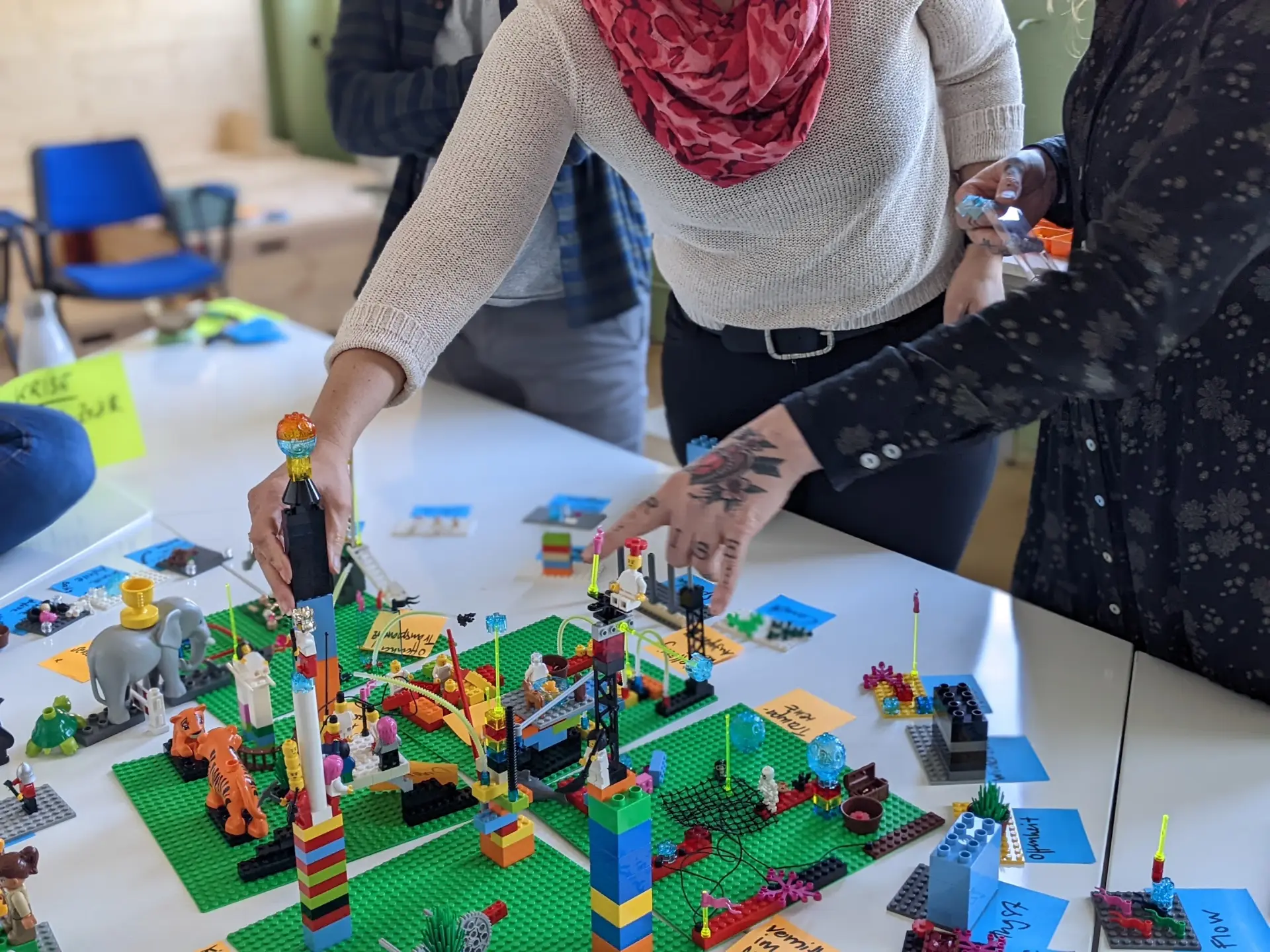 Hände bauen gemeinsam Modelle in einem LEGO Serious Play Workshop