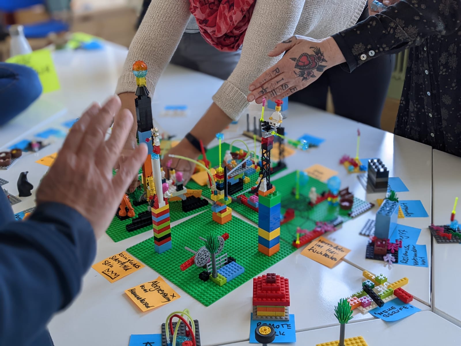 Gemeinsam gebaute LEGO® Serious Play® Landschaften auf einem Tisch im Deep Play Training